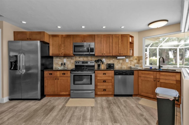 kitchen featuring light hardwood / wood-style flooring, sink, appliances with stainless steel finishes, and decorative backsplash