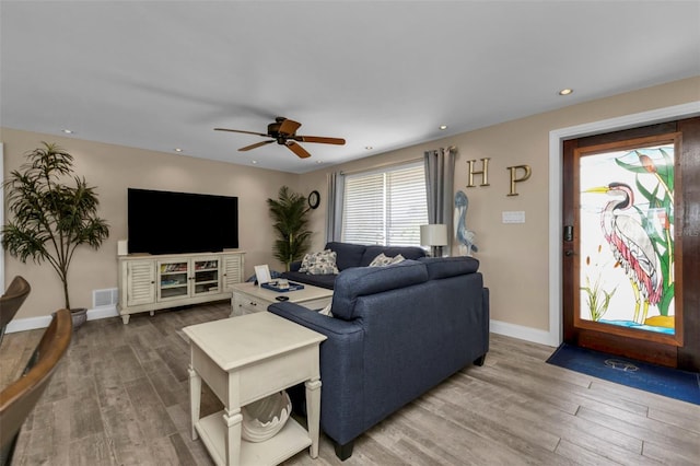 living room featuring ceiling fan and wood-type flooring