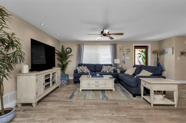 living room with light wood-type flooring and ceiling fan