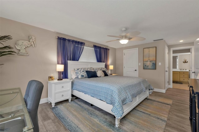 bedroom featuring hardwood / wood-style floors, ensuite bathroom, and ceiling fan