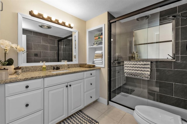 bathroom featuring vanity, toilet, walk in shower, and tile patterned floors