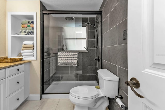 bathroom featuring tile patterned floors, walk in shower, toilet, vanity, and a textured ceiling