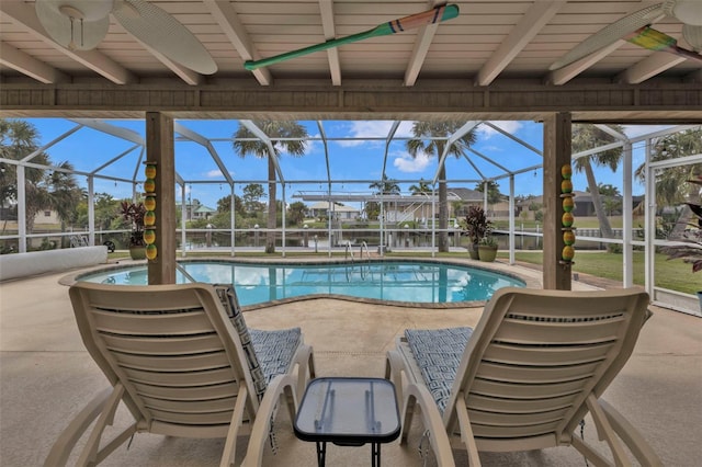 view of pool with glass enclosure, a patio area, and ceiling fan