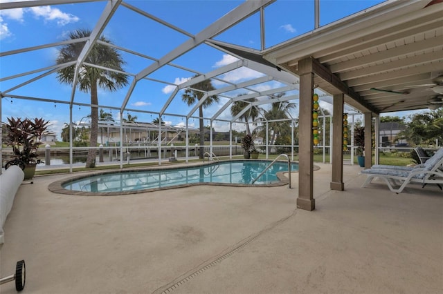 view of swimming pool with ceiling fan, a lanai, and a patio