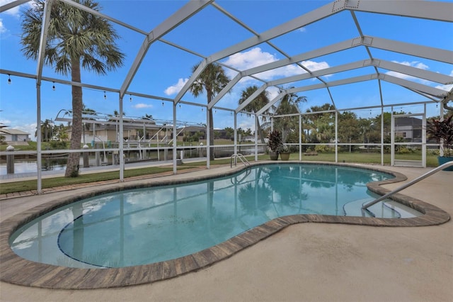 view of pool with glass enclosure and a patio