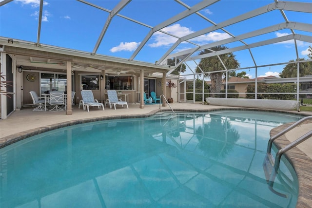 view of swimming pool with ceiling fan, a lanai, and a patio area