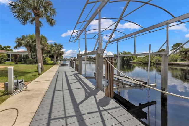 view of dock with a water view and a lawn