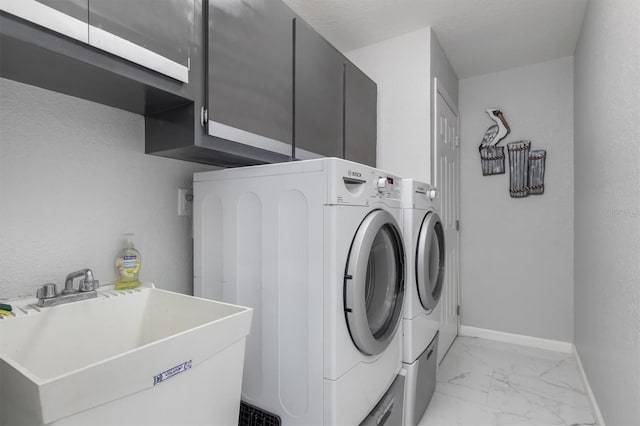 laundry area featuring washing machine and clothes dryer, sink, and cabinets