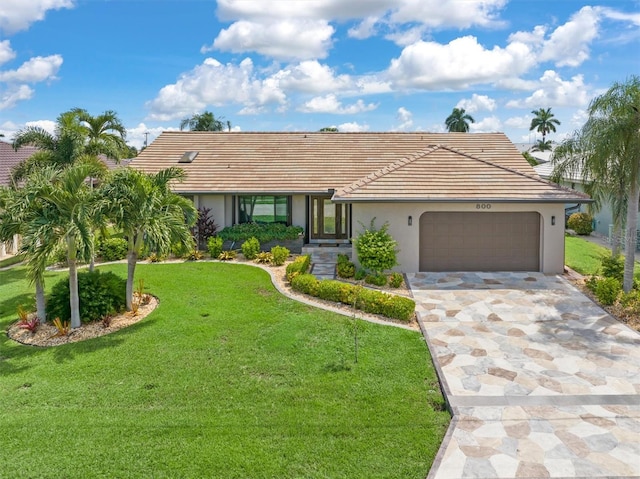 ranch-style house with a garage and a front lawn