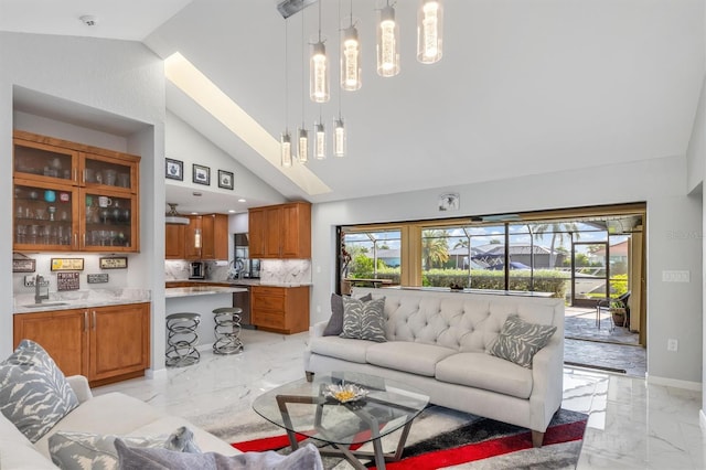 living room featuring high vaulted ceiling and sink