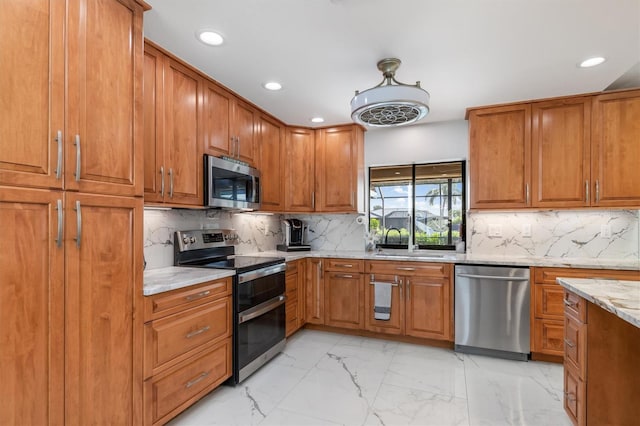 kitchen with decorative backsplash, appliances with stainless steel finishes, light stone counters, and sink