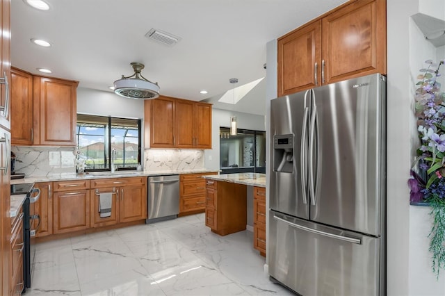 kitchen featuring sink, stainless steel appliances, light stone counters, pendant lighting, and decorative backsplash