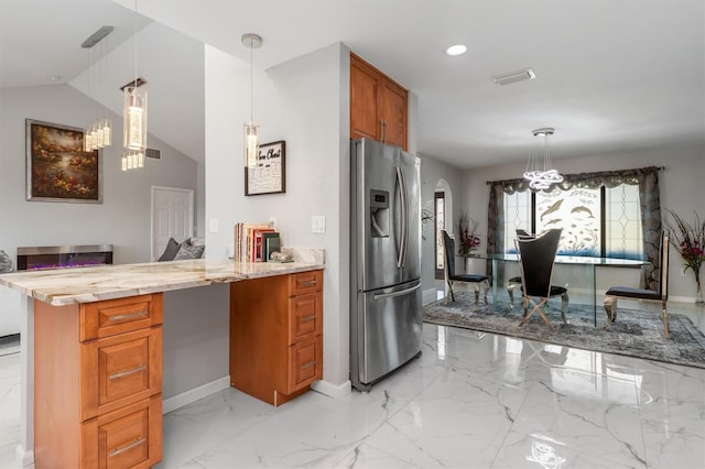 kitchen featuring lofted ceiling, an inviting chandelier, stainless steel fridge, decorative light fixtures, and kitchen peninsula