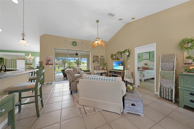 living room featuring ceiling fan with notable chandelier, high vaulted ceiling, and light tile patterned floors