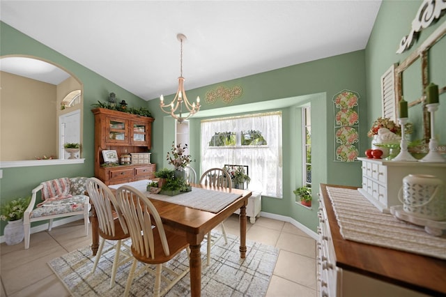 dining area with lofted ceiling, a chandelier, and light tile patterned floors