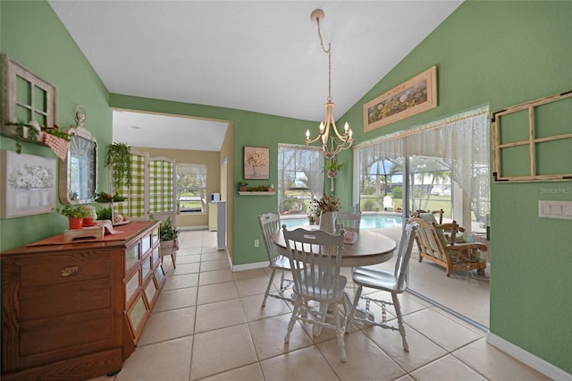 dining space with tile patterned floors, vaulted ceiling, baseboards, and a chandelier