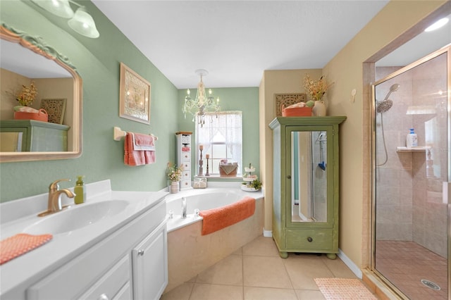 bathroom with a stall shower, a notable chandelier, vanity, a garden tub, and tile patterned flooring