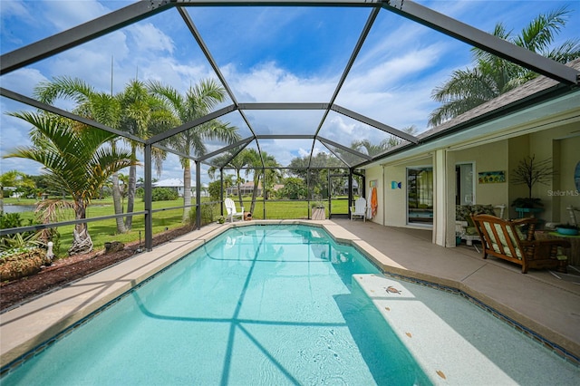 view of swimming pool featuring glass enclosure, a patio, and a lawn