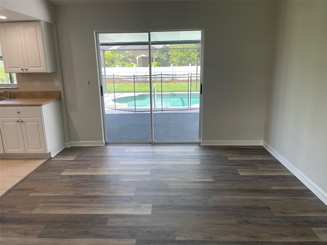 unfurnished dining area with dark hardwood / wood-style flooring and plenty of natural light