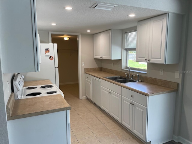 kitchen with a textured ceiling, sink, white cabinets, and white appliances