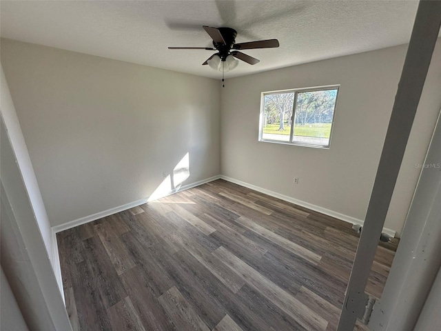 spare room with a textured ceiling, ceiling fan, and dark wood-type flooring