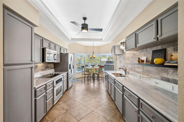 kitchen featuring ceiling fan with notable chandelier, light tile patterned floors, gray cabinets, stainless steel appliances, and sink