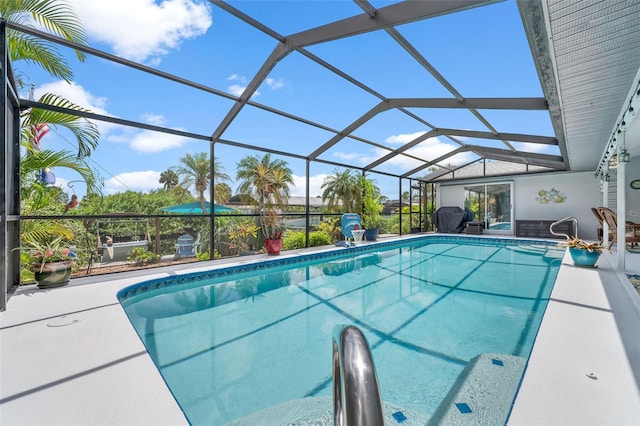 view of swimming pool featuring a lanai and a patio