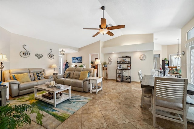 living room featuring ceiling fan with notable chandelier, vaulted ceiling, and light tile patterned floors