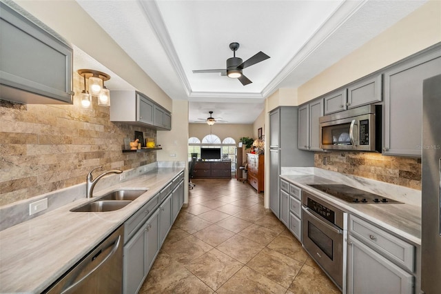 kitchen featuring ceiling fan, sink, gray cabinetry, stainless steel appliances, and decorative backsplash