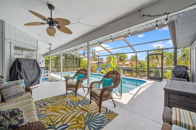 view of pool with ceiling fan, grilling area, glass enclosure, and a patio