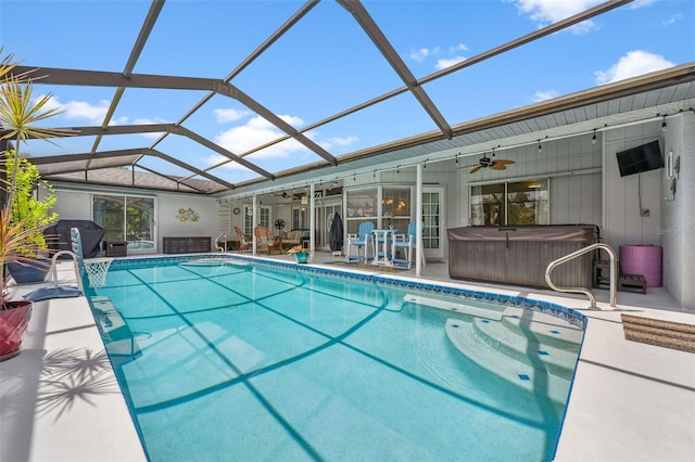 view of pool featuring glass enclosure, a patio, grilling area, ceiling fan, and a hot tub