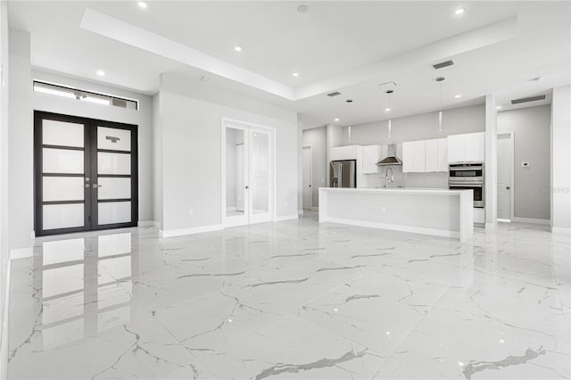 interior space with a raised ceiling and french doors