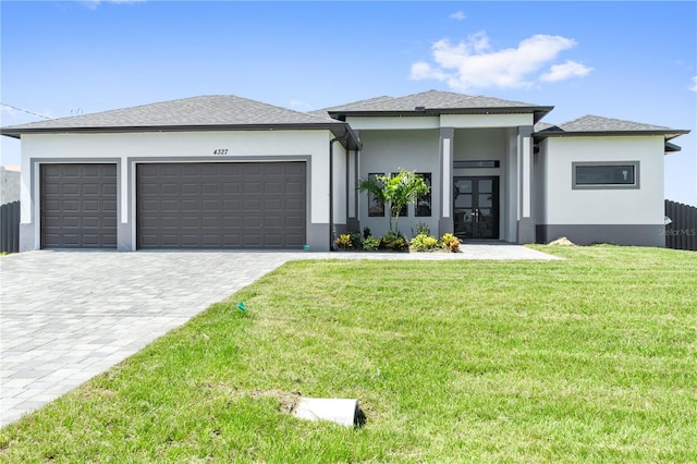 prairie-style home with a front yard and a garage