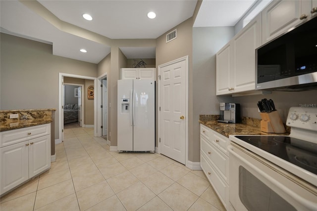 3959 San Rocco Ct Unit 911, Punta Gorda, FL 33950 - kitchen with white appliances, white cabinets, dark stone countertops, light tile patterned floors, and baseboards
