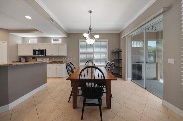 tiled dining area featuring a chandelier and crown molding