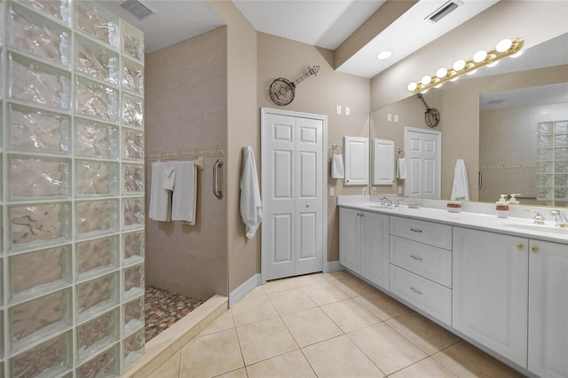 bathroom with vanity, tile patterned flooring, and tiled shower