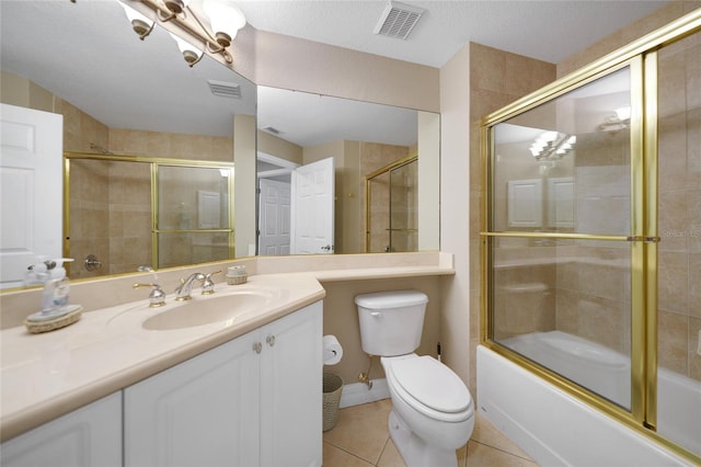 full bathroom with shower / bath combination with glass door, vanity, a textured ceiling, tile patterned flooring, and toilet