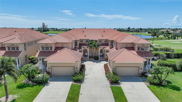 mediterranean / spanish home featuring a front lawn and a garage