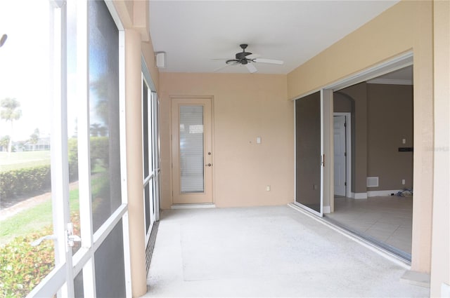 unfurnished sunroom with ceiling fan