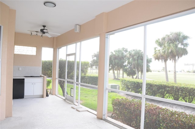 unfurnished sunroom with ceiling fan