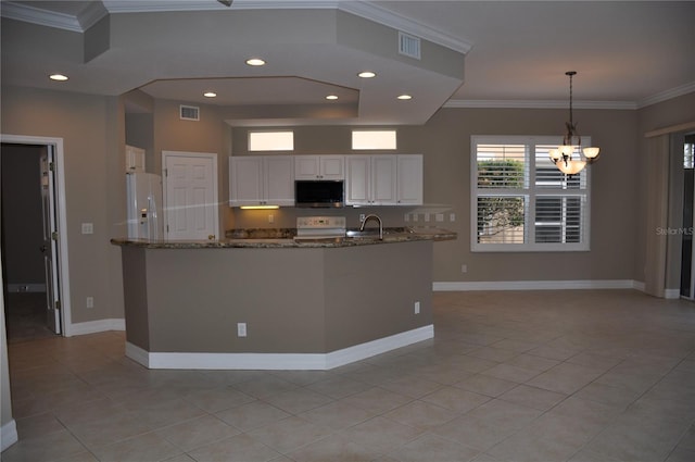 kitchen with an inviting chandelier, white cabinets, hanging light fixtures, range, and dark stone countertops