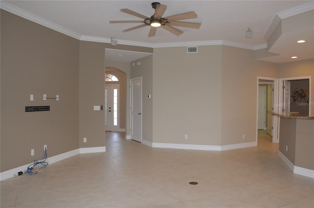 spare room with ceiling fan, light tile patterned floors, and crown molding