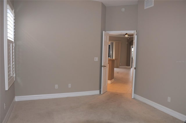 spare room featuring light carpet and ceiling fan