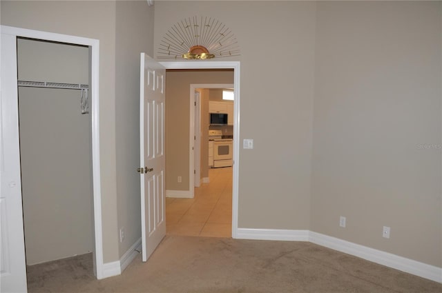 unfurnished bedroom with a closet and light carpet