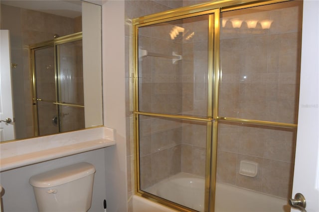 bathroom with toilet and shower / bath combination with glass door