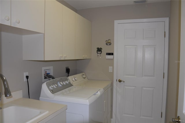 clothes washing area featuring cabinets, sink, and independent washer and dryer