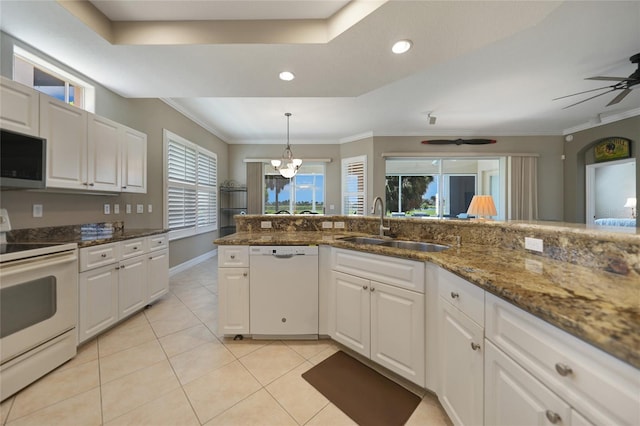 kitchen featuring white cabinets, dark stone counters, and white appliances