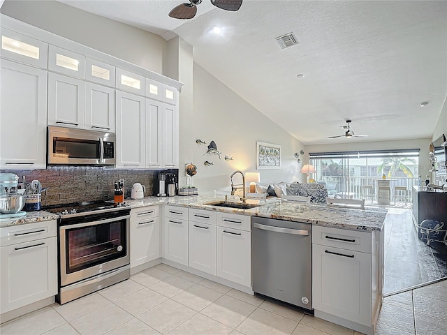 kitchen featuring ceiling fan, white cabinets, appliances with stainless steel finishes, and vaulted ceiling