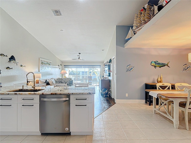 kitchen featuring white cabinets, light tile patterned floors, sink, stainless steel dishwasher, and light stone countertops