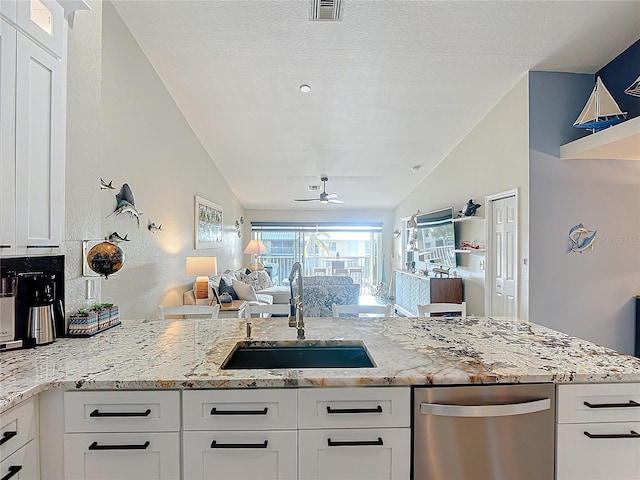 kitchen featuring light stone counters, sink, white cabinetry, vaulted ceiling, and ceiling fan